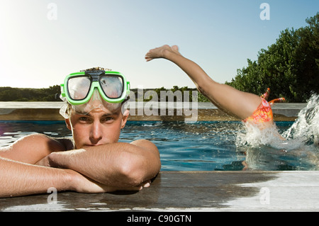 Junger Mann mit Schnorchel am Pool, Frau Tauchen in Stockfoto