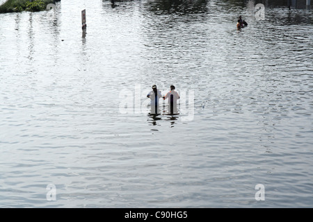 Menschen waten im Hochwasser an der Phetkasem Road in Bangkok Stockfoto