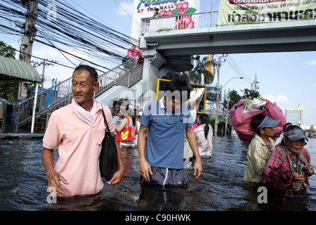 Menschen waten im Hochwasser an der Phetkasem Road in Bangkok Stockfoto