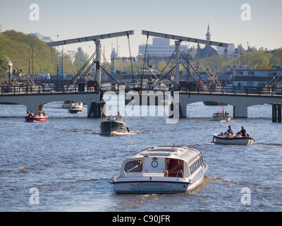 Verkehrsreichen Zentrum viele Boote auf dem Fluss Amstel, in der Stadt von Amsterdam, Niederlande Stockfoto