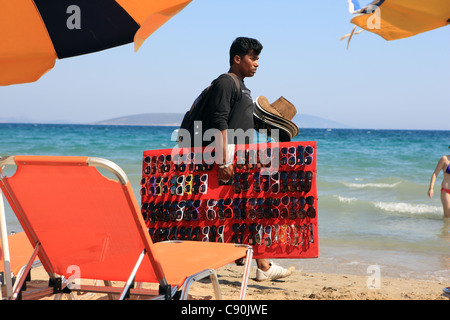 Looky looky Mann Verkauf von Sonnenbrillen und Hüte an einem Strand in Griechenland Stockfoto