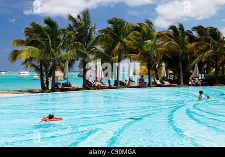 Menschen und Palmen Bäume am Pool des Beachcomber Hotel Paradis &amp; Golf Club, Mauritius, Afrika Stockfoto