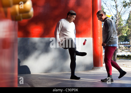 Morgen Sport in Jingshan Park zwei alte Männer spielen Badminton mit ihren Füßen rote Wände Westtor Peking Volksrepublik Stockfoto