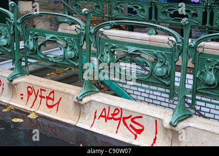 Jugendstil Galerie und rot Graffiti, Paris. Schöne Jugendstil-Geländer einer Metro-Station ist mit hässlichen Graffitis gegenübergestellt. Stockfoto