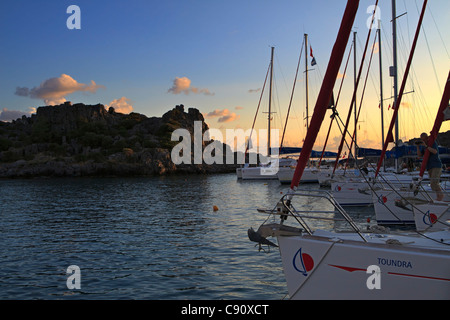 Charter Segelboote bei Sonnenuntergang in der Türkei, Lykische Küste. Eine Flotte von Yachten vor Anker in der Karacaoren Bucht. Stockfoto