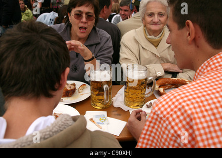 Familie genießt Bier und Speisen in der Hofbrau Festzelt auf dem Oktoberfest-Bierfest in München. Stockfoto