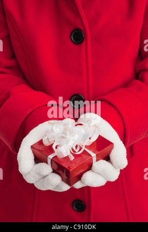 USA, Illinois, Metamora, Mädchen (10-11) mit roten Mantel hält kleine Geschenk-box Stockfoto