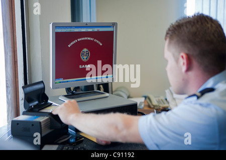 Hells Gate, Saba Insel Juancho Yrausquin Flughafen. Die Beamten der Einwanderungsbehörde Grenzschutzsystems auf Computer zu betrachten. Stockfoto