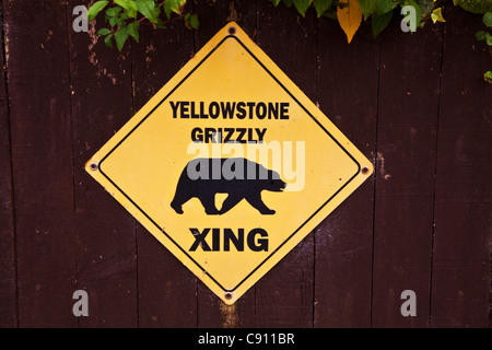 Grizzly Bär Warnzeichen vom Yellowstone National Park verschraubt mit einem Holzzaun in England, UK Stockfoto