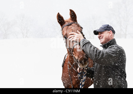 USA, Illinois, Metamora, lächelnd reifen Mann mit Pferd während blizzard Stockfoto