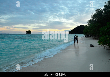 Romantisches Paar küssen am Strand, Wayag Insel, Raja Ampat Inseln, West-Papua, Indonesien in der Coral Triangle Pazifik. Stockfoto