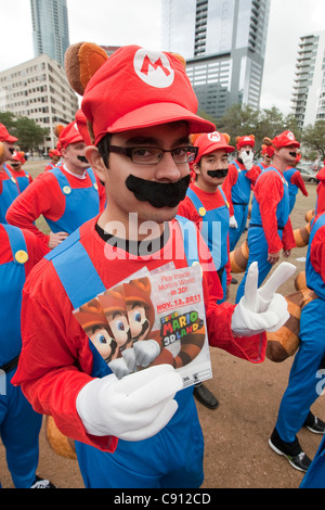 Heterogene Gruppe von Menschen, die engagiert für ein Flash-Mob-marketing-Kampagne von Nintendo, Super Mario 3D Insel, ein neues Videospiel zu fördern Stockfoto