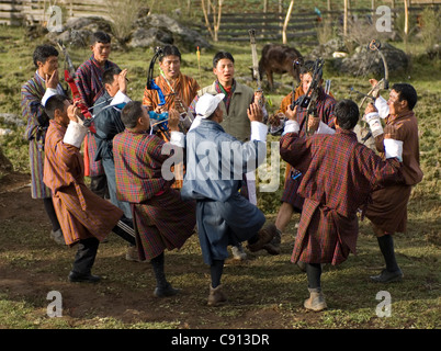 Wenn jemand das Ziel trifft, ist das gesamte Team in einem Inter Dorf Wettschießen in Bhutan eine Gesang und Tanz-Routine. Stockfoto