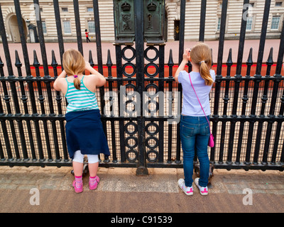 Zwei junge Mädchen Touristen fotografieren vor den Toren des Buckingham Palace Westminster London England UK Stockfoto