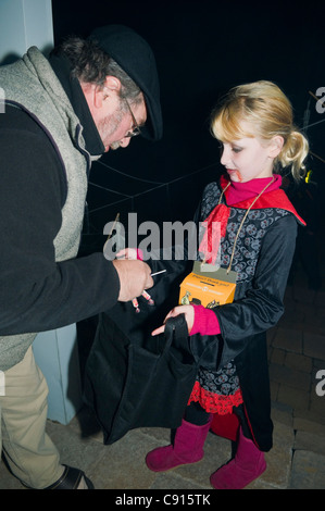 Kind, sammeln von Süßigkeiten während Trick und Vergnügen an Halloween Night Canada Stockfoto