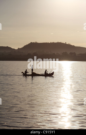 Drei afrikanische madagassischen Fischer in ihren Einbaum-Ausleger-Kanu, Rudern in den frühen Morgenstunden am Krater Bay, Nosy Be, Madagaskar Stockfoto