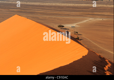 Menschen zu Fuß auf roten Sanddüne in Sossusvlei Düne 45, Wüste Namib-Naukluft-Nationalpark, Sossusvlei, Namib, Namib, Namibia Stockfoto