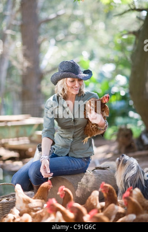 Frau Fütterung Hühner auf Bauernhof Stockfoto