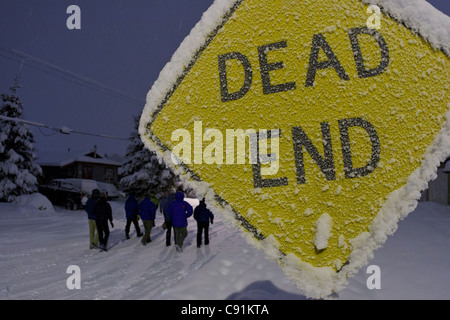 Gruppe von Menschen Fuß Vergangenheit, die ein schneebedeckter und frostigen Sackgasse in einer Wohngegend, Anchorage, Alaska zu unterzeichnen Stockfoto
