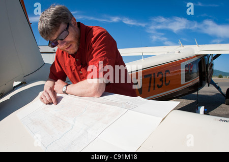 Helio Courier Pilot berät eine Karte vor immer bereit, die Arctic National Wildlife Refuge, Fairbanks Alaska fliegen Stockfoto
