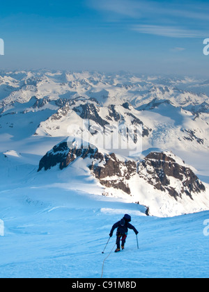 Kletterer stützte sich in starkem Wind auf Nordwest Grat des Mount Iliamna oben Zunge Gletscher und Chigmit Mountains, Frühling, Alaska Stockfoto