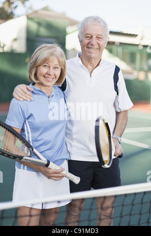 Älteres paar stehen auf Tennisplatz Stockfoto