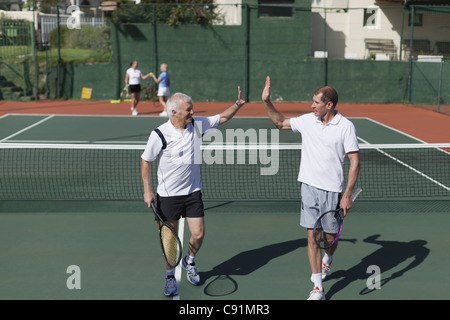 Ältere Männer zuerst auf Tennisplatz Stockfoto