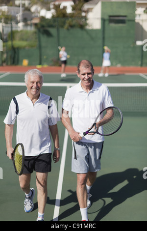Ältere Männer zu Fuß auf Tennisplatz Stockfoto