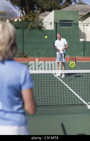Älteres Ehepaar mit dem Tennisspielen auf Platz Stockfoto