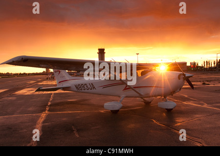 Die Sonne versinkt hinter einer Cessna 172 bei Merrill Field in Anchorage, Alaska Yunan, Sommer Stockfoto