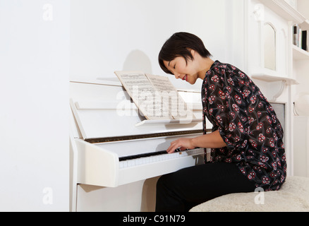 Frau zu Hause Klavier spielen Stockfoto