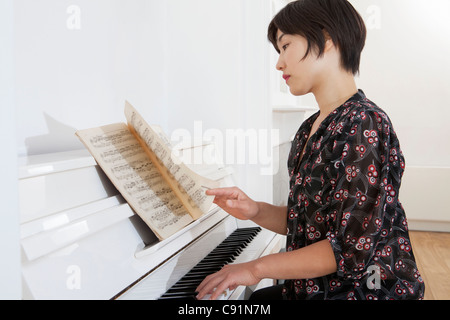 Frau zu Hause Klavier spielen Stockfoto