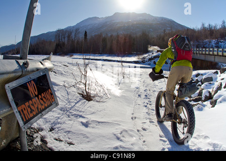 Mann Radfahren hinter einem No Trespassing Zeichen entlang der Knik River auf den Knik-Gletscher auf dem fetten Reifen Fahrrad, Chugach Mountains, Alaska Stockfoto