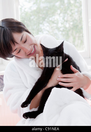 Frau im Bademantel Holding Katze Stockfoto