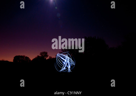 L.e.d Fackel, versponnen Wunderschöne kreisförmige Streifen von blauem Licht zu machen, die auf einem klaren Sternenhimmel winter Abend. Stockfoto