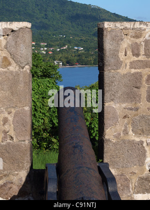 Ein Kanon zwischen zwei Steinmauern in Fort Shirley, Cabrits National Park, Commonwealth of Dominica, Westindien, Karibik. Stockfoto