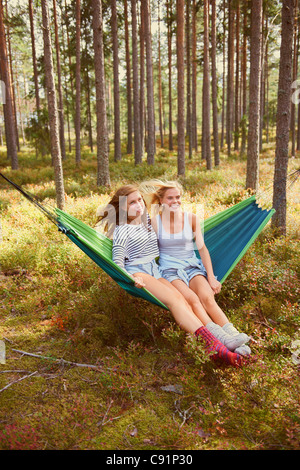 Frauen, die zum Entspannen in der Hängematte im Wald Stockfoto