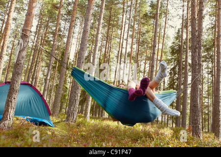 Frauen, die zum Entspannen in der Hängematte auf Campingplatz Stockfoto