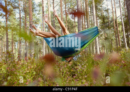 Frauen, die zum Entspannen in der Hängematte im Wald Stockfoto