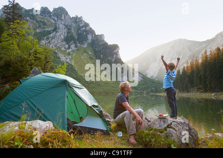Vater und Sohn entspannend auf Campingplatz Stockfoto