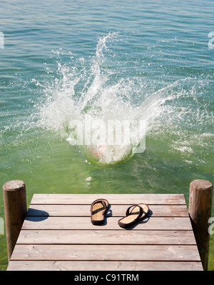 Flip Flops auf Holzterrasse See Stockfoto