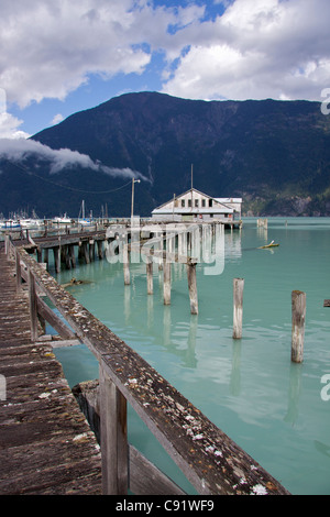 Bella Coola River erreicht das Meer an der Mündung und gibt es eine stillgelegte Wharf und Pier am Ufer. Stockfoto