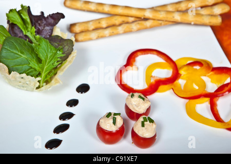 Cherry-Tomaten gefüllt mit streichfähiger Käse serviert mit Brot-Sticks und Gemüse Stockfoto