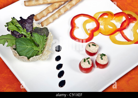 Cherry-Tomaten gefüllt mit streichfähiger Käse serviert mit Brot-Sticks und Gemüse Stockfoto