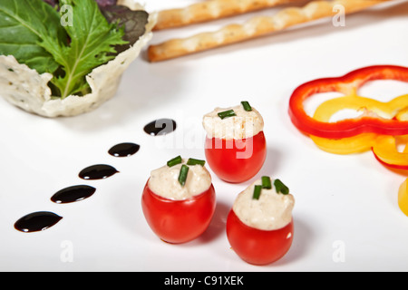 Cherry-Tomaten gefüllt mit streichfähiger Käse serviert mit Brot-Sticks und Gemüse Stockfoto