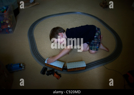 Ein kleiner Junge spielt mit seinem Zug auf dem Dachboden. Stockfoto