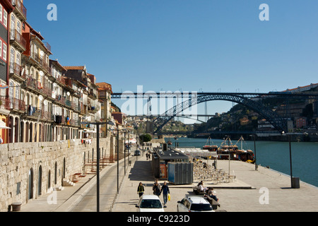 Ribeira am Ufer Bezirk von Porto mit mittelalterlichen Stadtmauer unterhalb 5-geschossige Häuser mit Balkonen hängen Wäsche mit Ponte Dom Luis Stockfoto