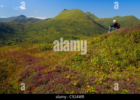 Wanderer entspannt auf Säule Berg mit den drei Schwestern Bergen im Hintergrund, phantastische Kodiak Island, Alaska Stockfoto