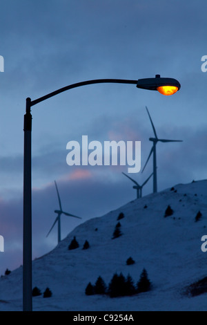 Lampe leuchtet warm am späten Nachmittag mit Windkraftanlagen auf Säule Berg hinter der Stadt Kodiak, Südwest-Alaska post Stockfoto