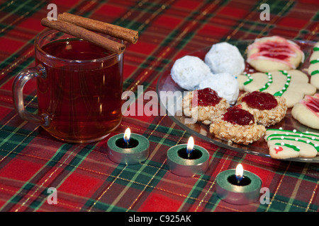 Nahaufnahme der hausgemachte Weihnachtskekse auf Glasplatte mit heißen gewürzten Apfelwein trinken aus seitlich angeordnet Stockfoto